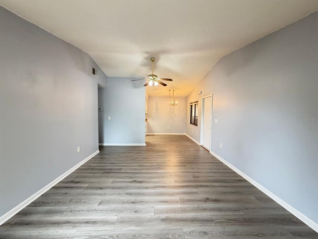 An empty room with light gray walls, wood-look flooring, and a ceiling fan — 5239 VINELAND ROAD UNIT A203, ORLANDO, FL