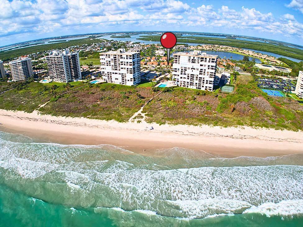 An aerial view shows beachfront high-rise condominiums with a red location pin above one building — 204 River Walk, Fort Pierce FL 34949, FORT PIERCE, FL