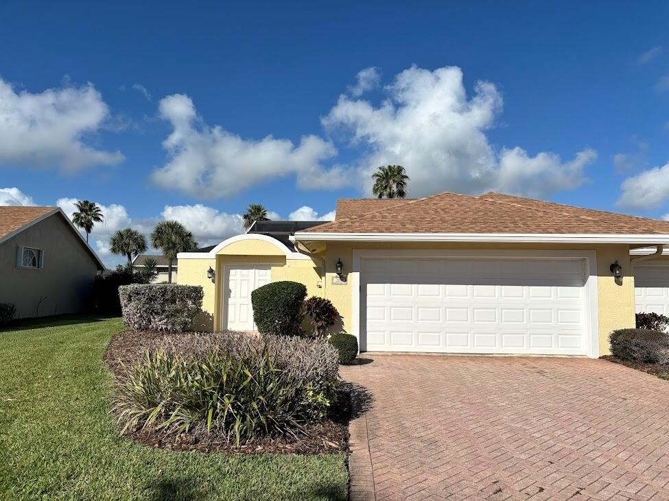 A single-story house with a yellow exterior, a white garage door, and a brick driveway — 204 River Walk, Fort Pierce FL 34949, FORT PIERCE, FL