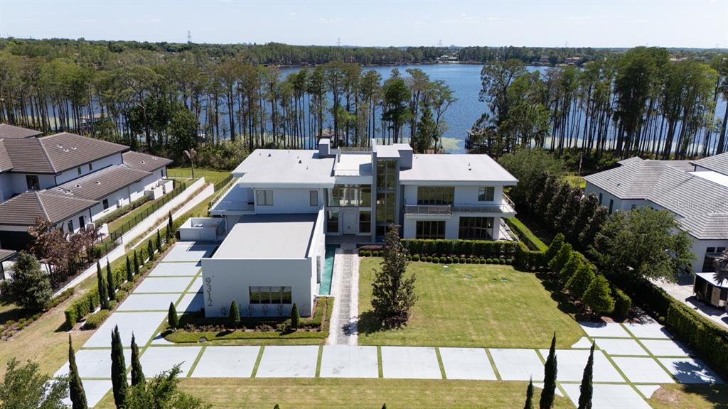 An aerial view shows a modern white house with a flat roof and large lawn — 9312 BLANCHE COVE DR, WINDERMERE, FL