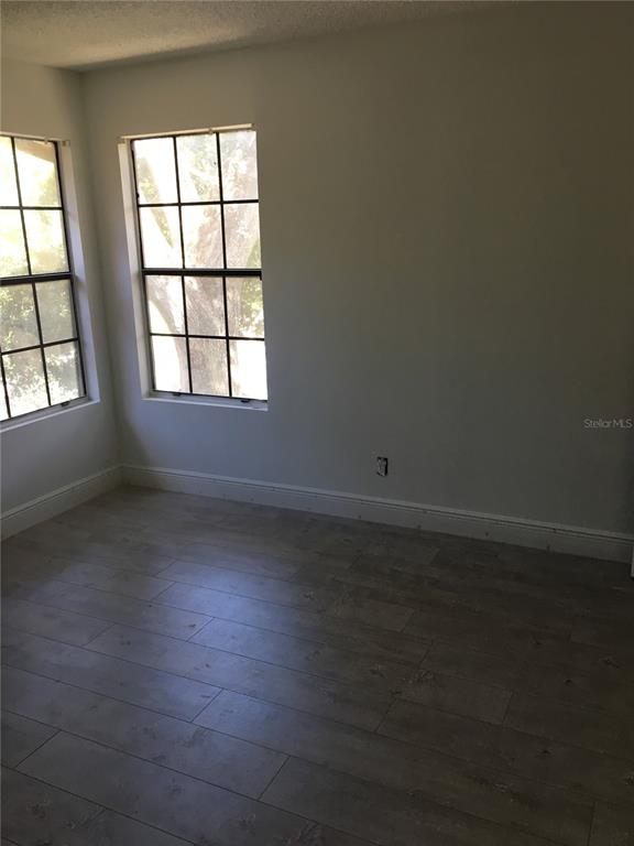 An empty room features light-colored wood-look flooring, white walls, and two windows with grids — 375 LAKE ONTARIO COURT UNIT 301, ALTAMONTE SPRINGS, FL