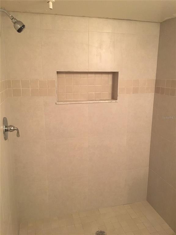 A tiled walk-in shower features a built-in wall niche, a showerhead, and a chrome faucet — 375 LAKE ONTARIO COURT UNIT 301, ALTAMONTE SPRINGS, FL