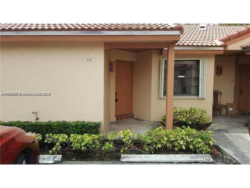 The exterior of a tan stucco house features a tiled roof, a wooden door, and landscaping — 17268 NW 60th Ct, Hialeah FL 33015, HIALEAH, FL