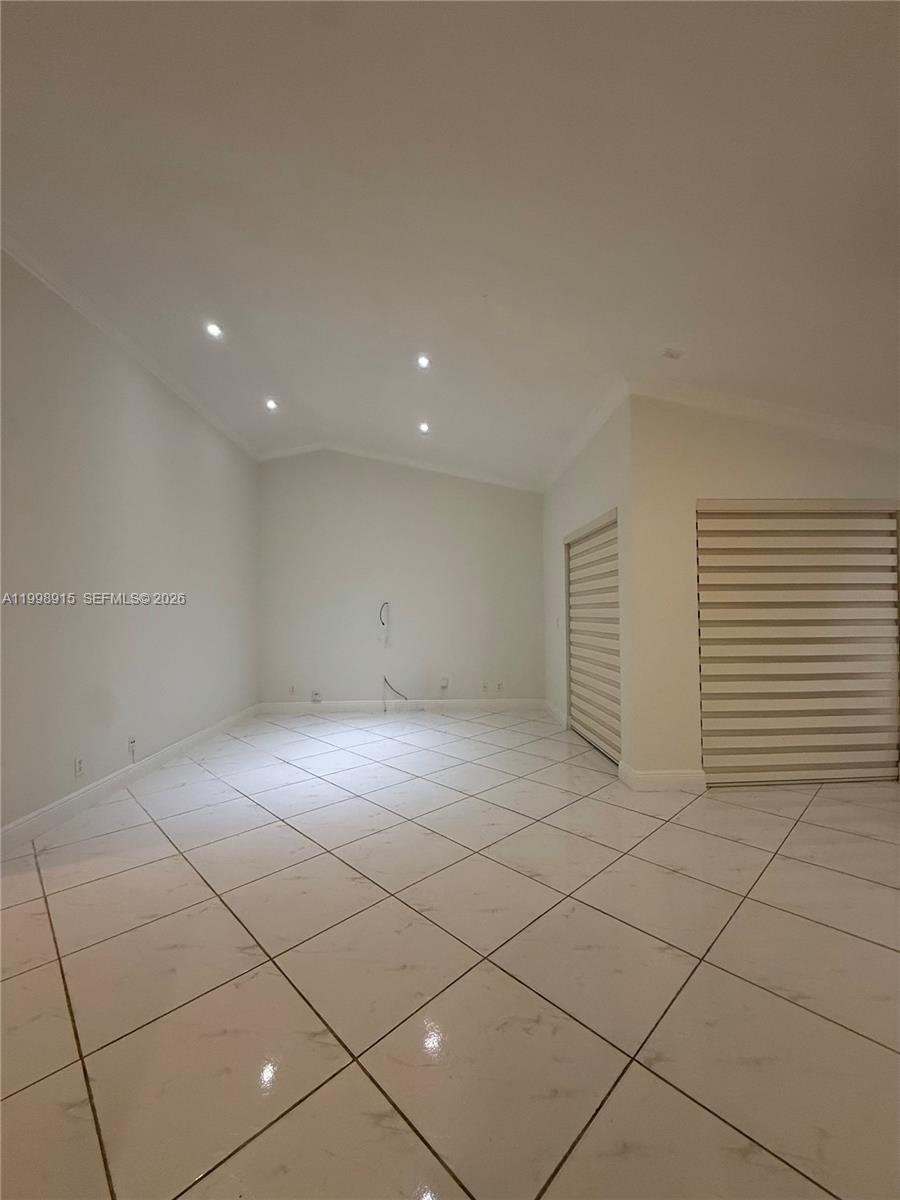 An empty room features white tiled floors, recessed ceiling lights, and two windows with blinds — 17268 NW 60th Ct, Hialeah FL 33015, HIALEAH, FL
