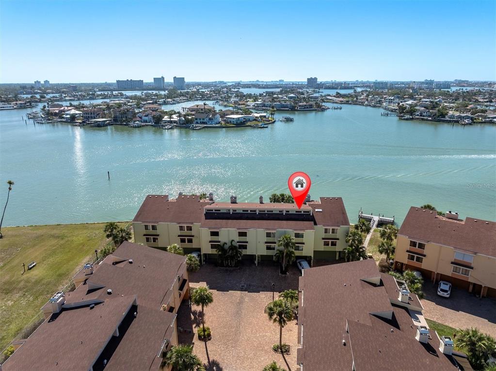 An aerial view shows a multi-story residential building complex situated along a waterfront — 553 HAVEN POINT DRIVE, TREASURE ISLAND, FL