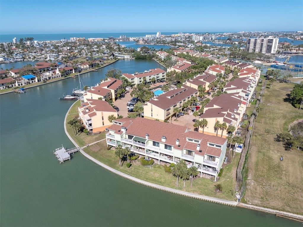 An aerial view shows a waterfront condominium complex with brown roofs and a boat dock — 553 HAVEN POINT DRIVE, TREASURE ISLAND, FL
