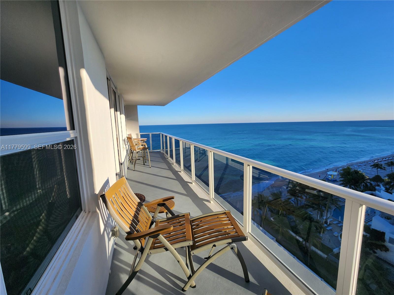 A balcony with lounge chairs overlooks the ocean and beach — 3505 S Ocean Dr # 1214, Hollywood FL 33019, HOLLYWOOD, FL