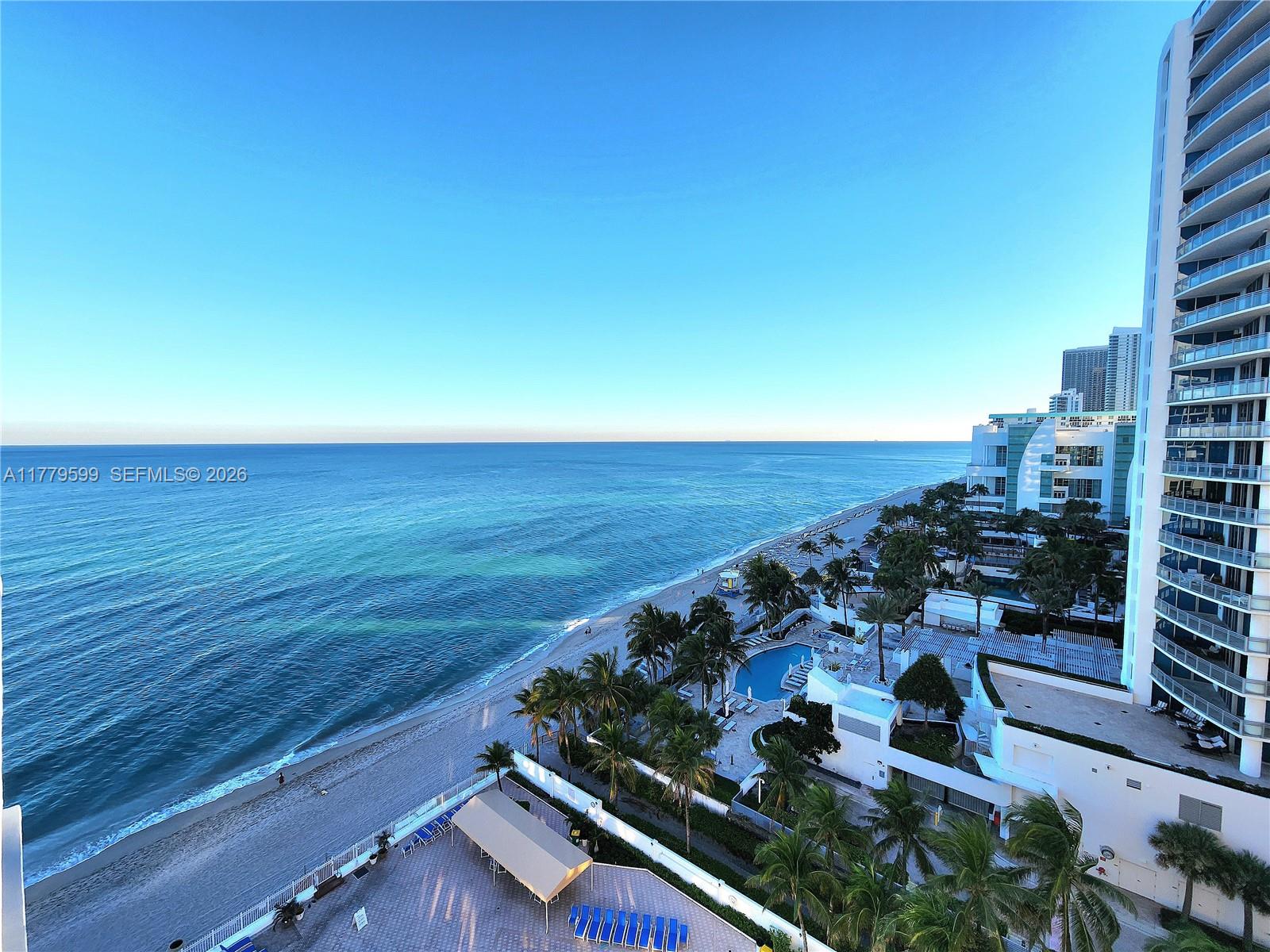 An elevated view of a beach, ocean, and coastal high-rise buildings with a swimming pool — 3505 S Ocean Dr # 1214, Hollywood FL 33019, HOLLYWOOD, FL
