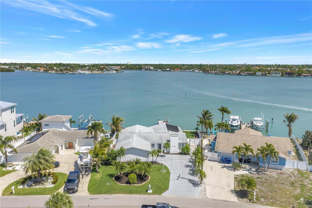 An aerial view of three waterfront houses with docks and boats along a bay — 6984 S SHORE DRIVE S, ST PETERSBURG, FL
