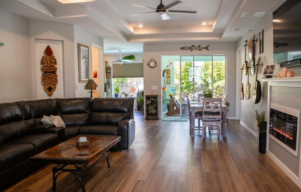 A living room with a leather sectional, wood coffee table, and guitars mounted on the wall — 4 ULMACEA PLACE, PALM COAST, FL