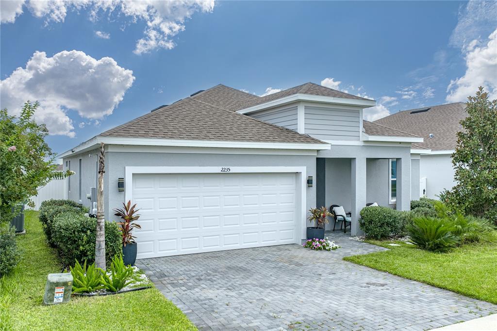 This aerial view shows a single-family home with a fenced backyard and driveway — 2235 PIGEON PLUM DRIVE, HAINES CITY, FL