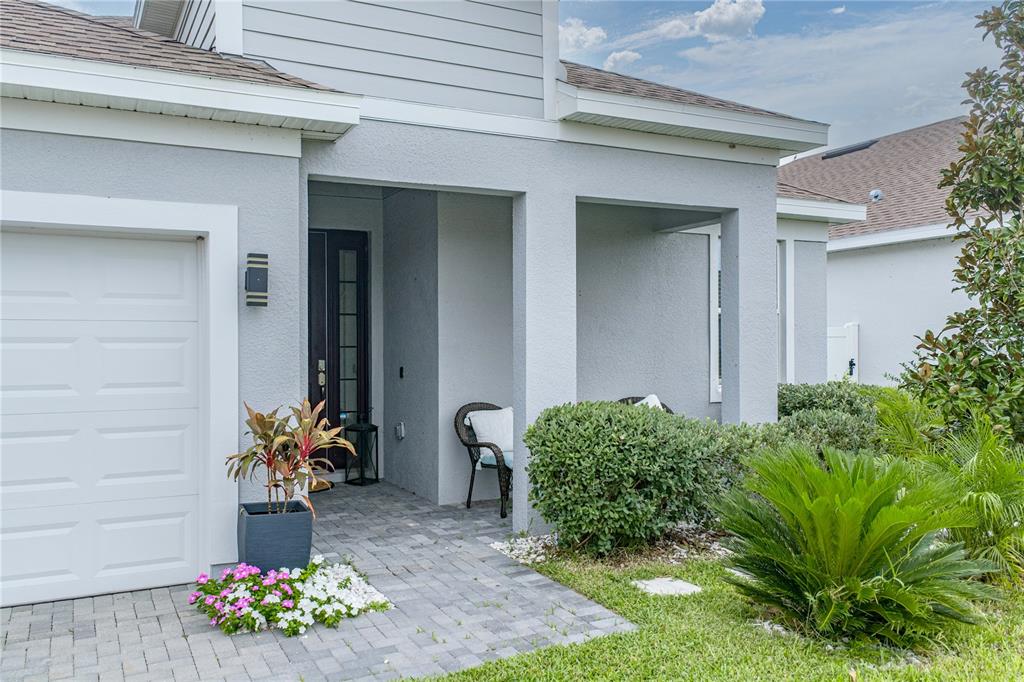 A single-story house with a white garage door, gray stucco exterior, and a paved driveway — 2235 PIGEON PLUM DRIVE, HAINES CITY, FL