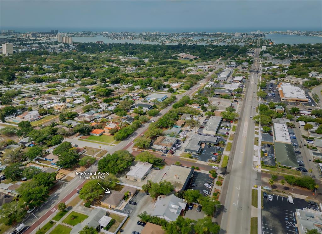 An aerial view shows a single-story building surrounded by trees, parking lots, and city streets — 6465 1ST AVENUE S, ST PETERSBURG, FL