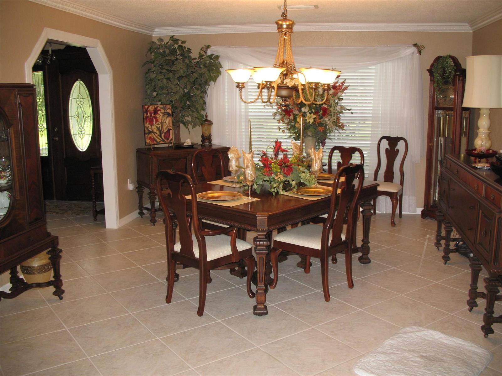 A formal dining room features a dark wood table, matching chairs, and a chandelier — 555 SW 87th Place, Ocala FL 34476, OCALA, FL