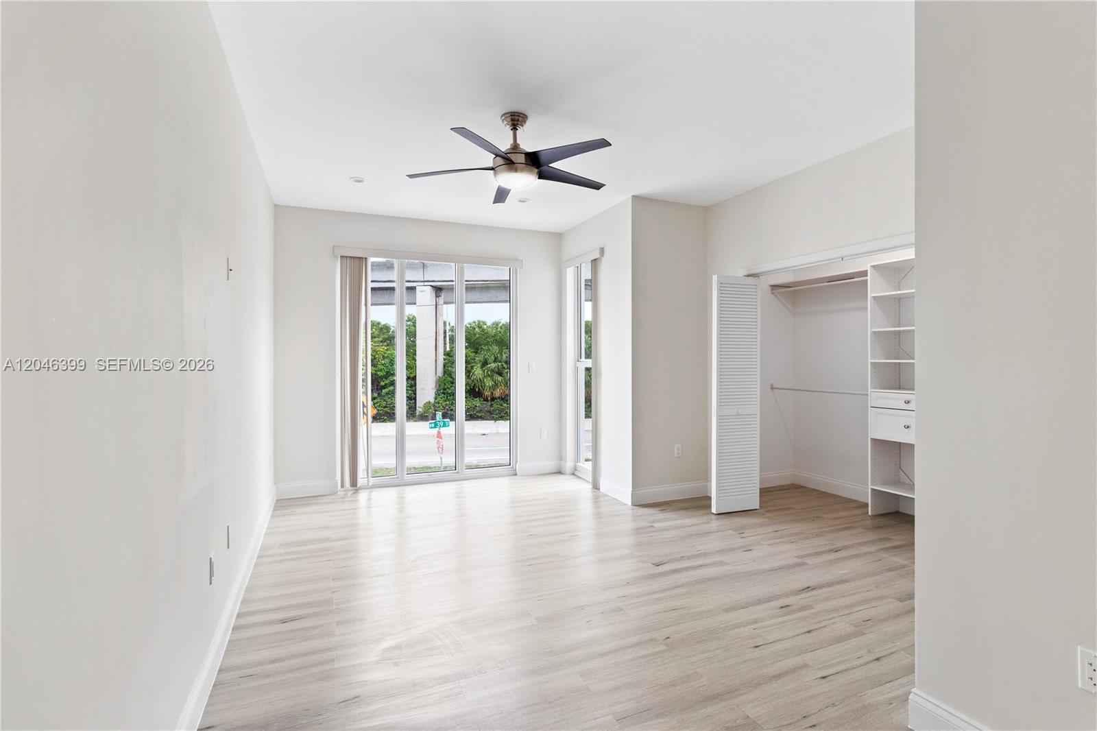 An empty bedroom features light wood-look flooring, a ceiling fan, and a built-in closet — 1252 NW 39th St # 1252, Miami FL 33142, MIAMI, FL
