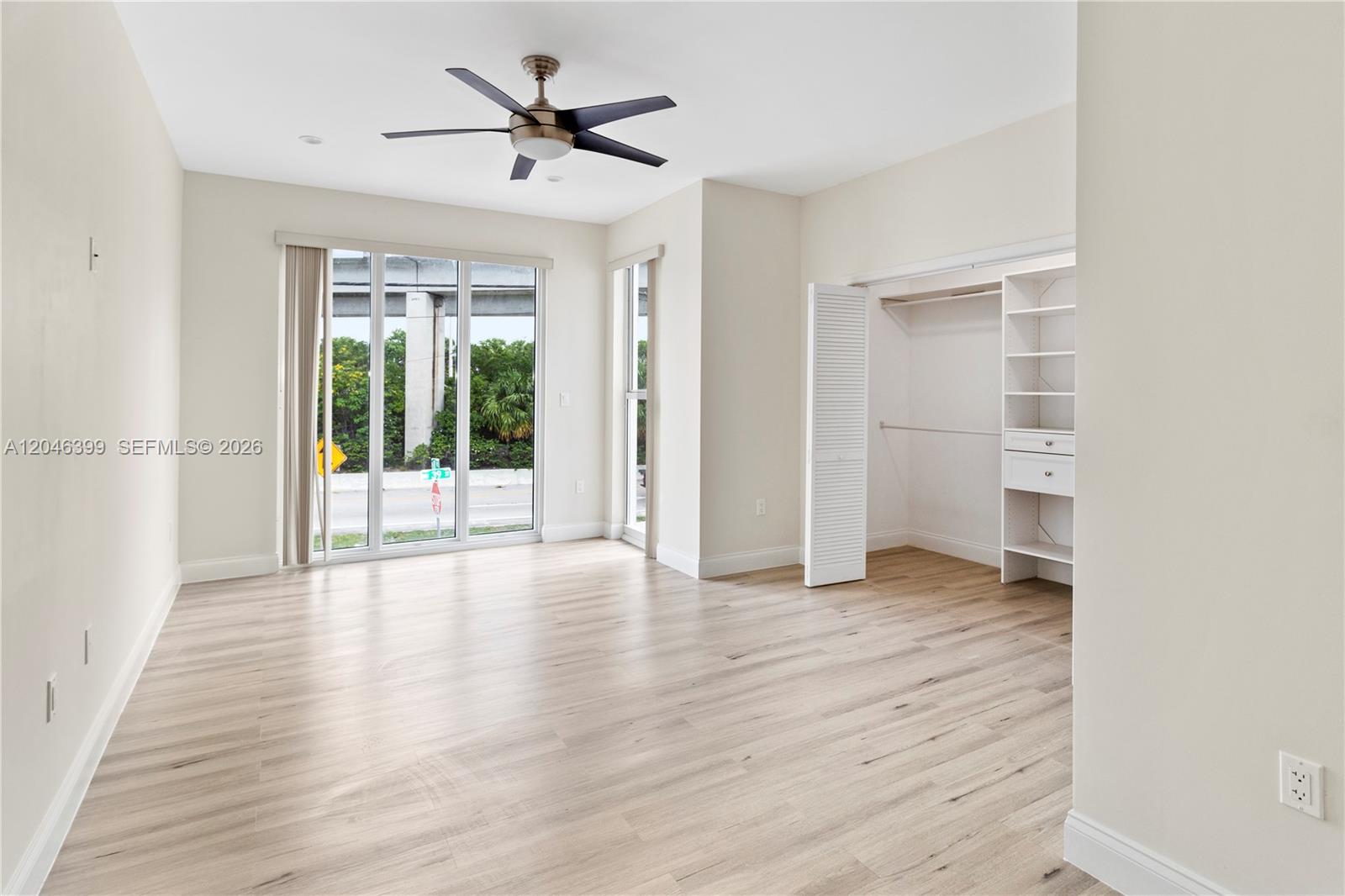 An empty bedroom features light wood-look flooring, a ceiling fan, and a built-in closet — 1252 NW 39th St # 1252, Miami FL 33142, MIAMI, FL
