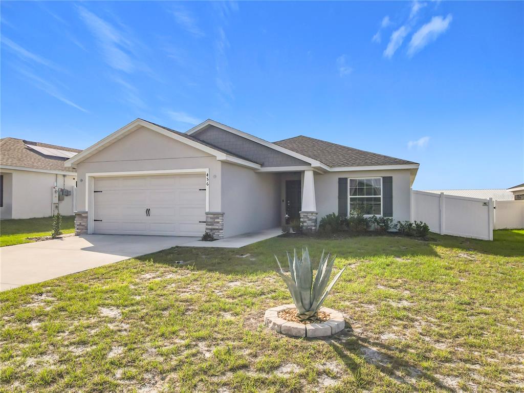 A single-story house with a two-car garage, stone accents, and a front yard agave plant — 456 HILLTOP DRIVE, LAKE WALES, FL