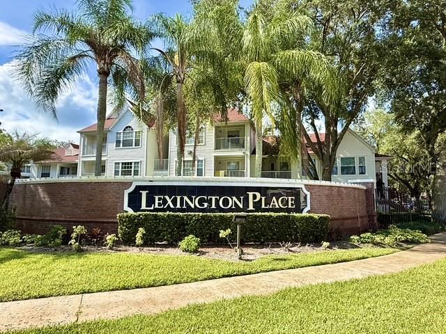 A brick sign for Lexington Place stands in front of a multi-story apartment complex — 11594 WESTWOOD BOULEVARD UNIT 1617, ORLANDO, FL