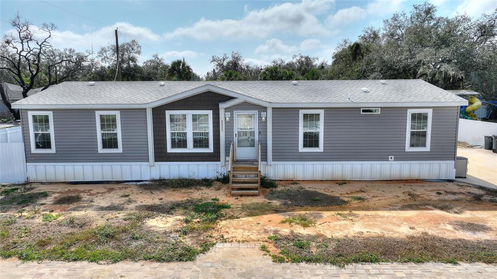 A single-story manufactured home with gray horizontal siding and a central brown accent section — 2337 E MAIN STREET, LAKELAND, FL
