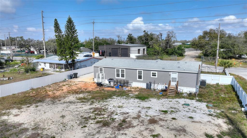 An aerial view shows a gray manufactured home with a large, sandy yard and fencing — 2337 E MAIN STREET, LAKELAND, FL