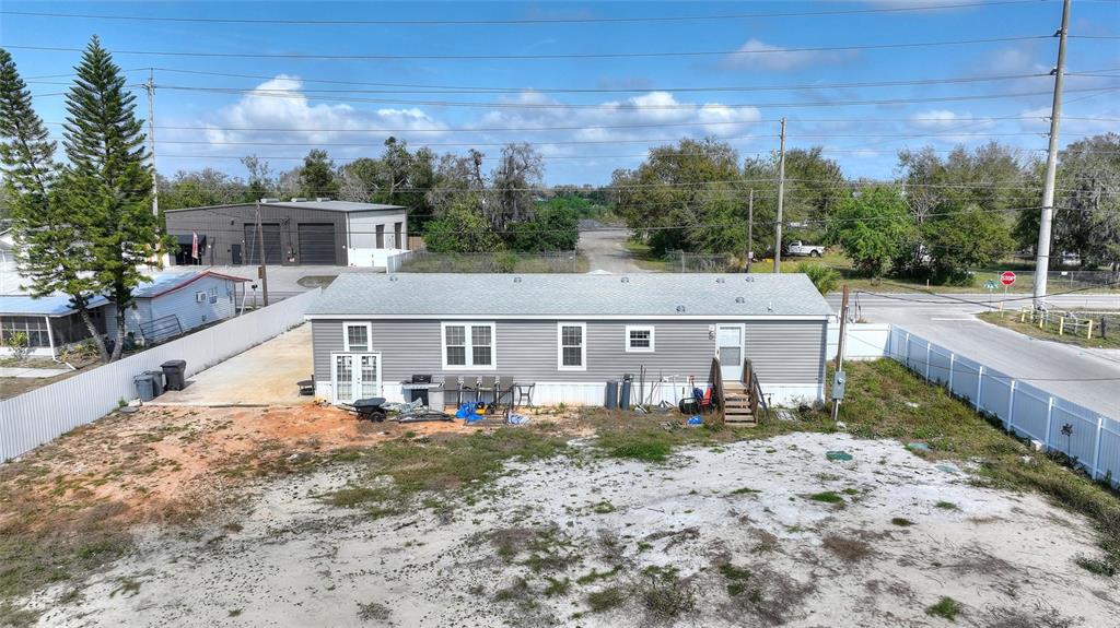 An exterior view of a single-story gray manufactured home with a fenced yard — 2337 E MAIN STREET, LAKELAND, FL