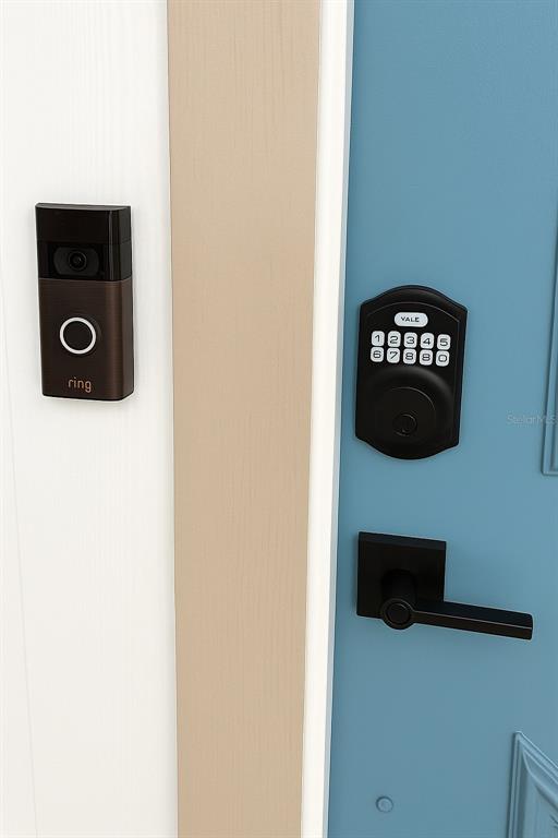 A close-up view of a blue door featuring a black keypad lock and a Ring doorbell — 1211 CAPRI ISLES BOULEVARD UNIT 6, VENICE, FL