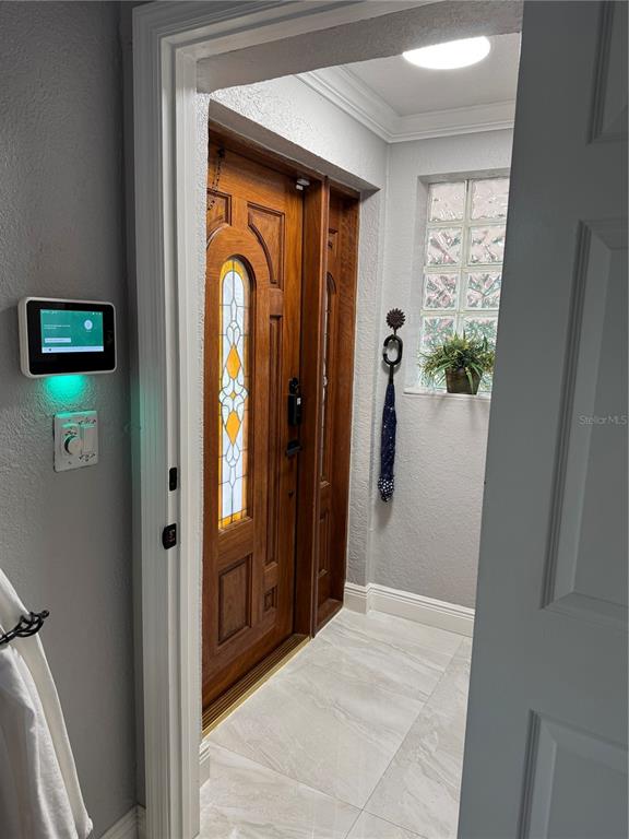 An entryway features a wooden front door with stained glass, tile flooring, and a wall-mounted tablet — 14821 PALMETTO PALM AVENUE, MIAMI LAKES, FL