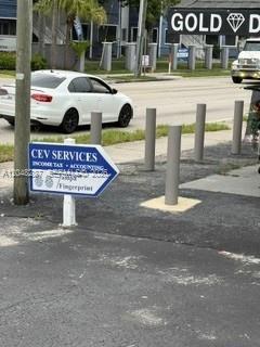 A white sedan is parked on a street next to a sign for CEV Services — 4603 N Armenia, Tampa FL 33603, TAMPA, FL