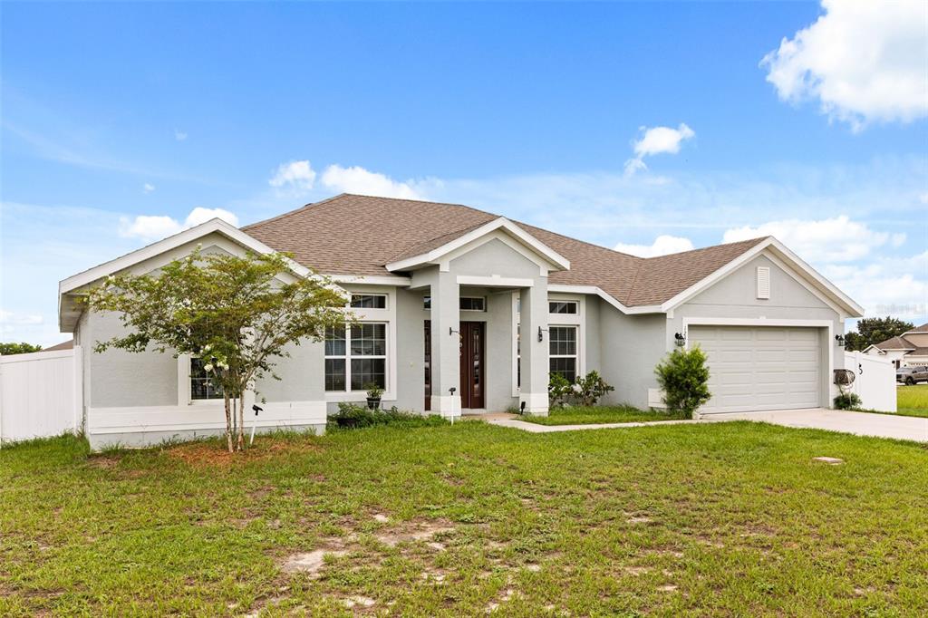 A single-story house with a light gray stucco exterior, a brown roof, and a garage — 1234 NELSON PARK CT, POINCIANA, FL