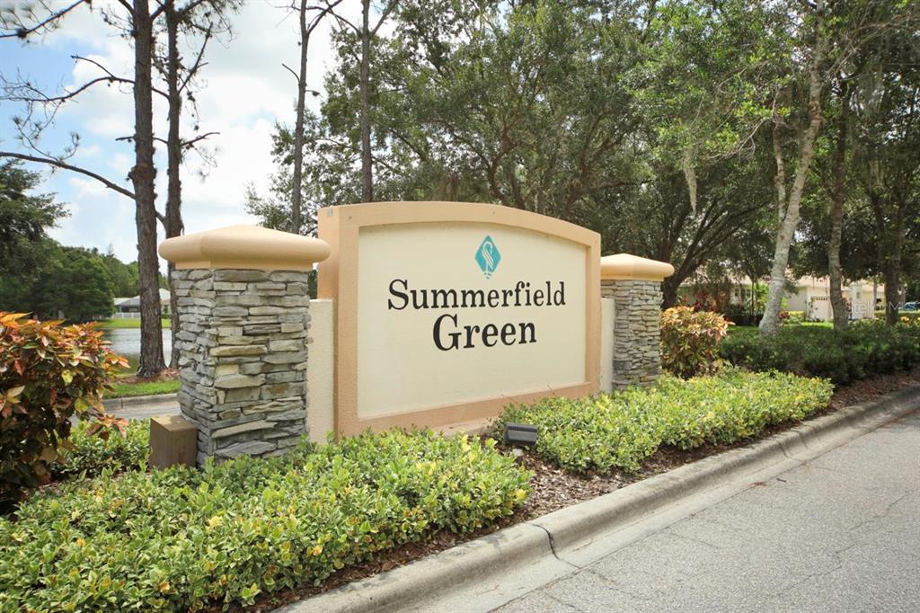A stone and stucco monument sign for Summerfield Green stands near a road and trees — 11914 SOFT RUSH TERRACE, LAKEWOOD RANCH, FL