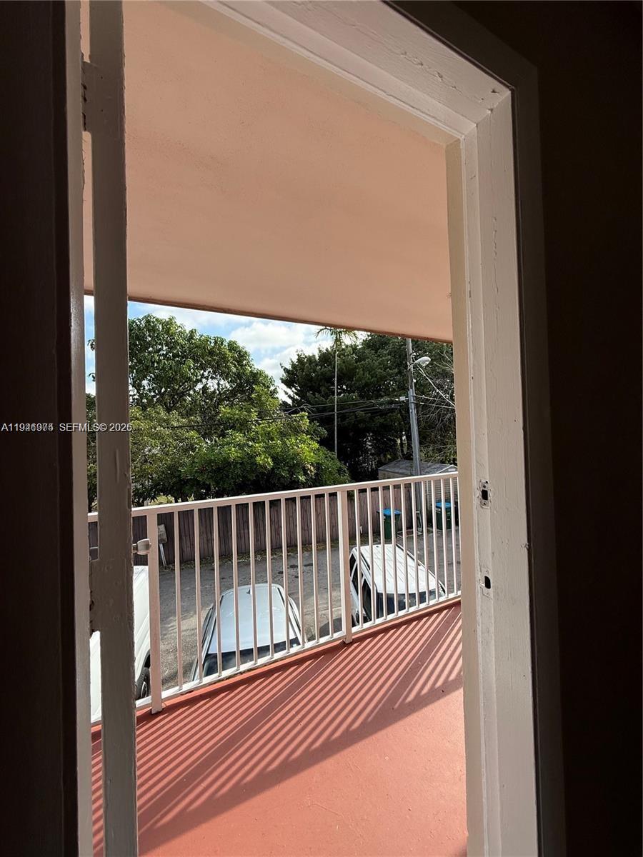 A view from a doorway looking out onto a balcony with a white metal railing — 2915 Plunkett St # 12A, Hollywood FL 33020, HOLLYWOOD, FL