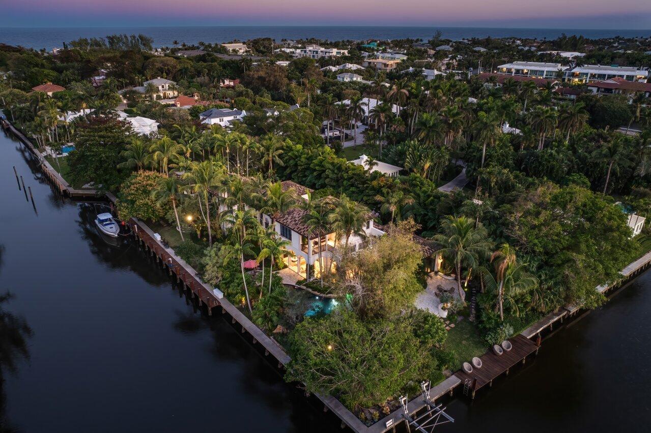 Aerial view of a waterfront house with a pool, boat dock, and lush tropical landscaping — 8 Driftwood Landing, Gulf Stream FL 33483, GULF STREAM, FL
