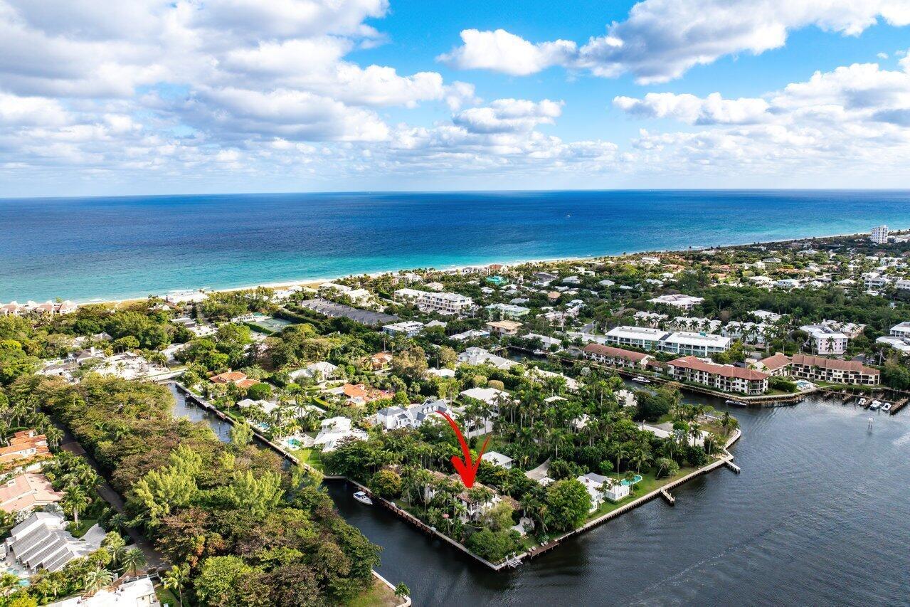 An aerial view shows a waterfront house with a red arrow pointing to the property — 8 Driftwood Landing, Gulf Stream FL 33483, GULF STREAM, FL