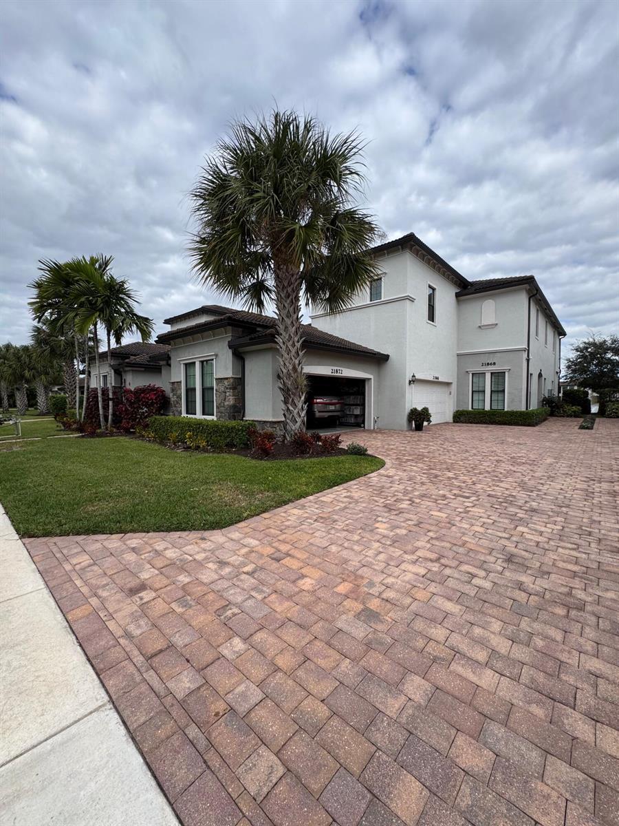 A two-story stucco house with a paver driveway and palm trees in the front yard — 21872 Canadensis Circle # 202, Boca Raton FL 33428, BOCA RATON, FL