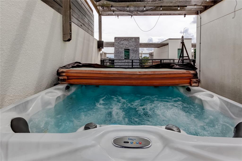 A hot tub with a partially open cover sits on an outdoor rooftop deck — 2511 N GRADY AVENUE UNIT 78, TAMPA, FL