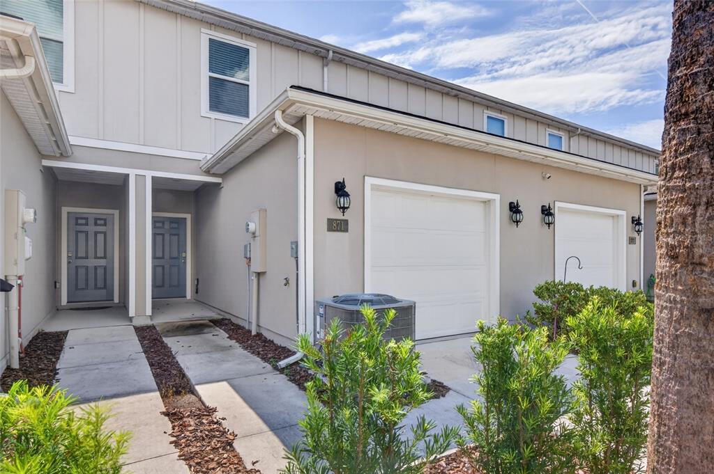A kitchen with white cabinets, stainless steel appliances, a center island, and wood-look flooring — 871 RIVERTREE PLACE, MIDDLEBURG, FL