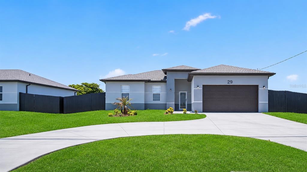 A single-story house with a gray exterior, a two-car garage, and a concrete driveway — 29 DIPLOMAT PARKWAY E, CAPE CORAL, FL