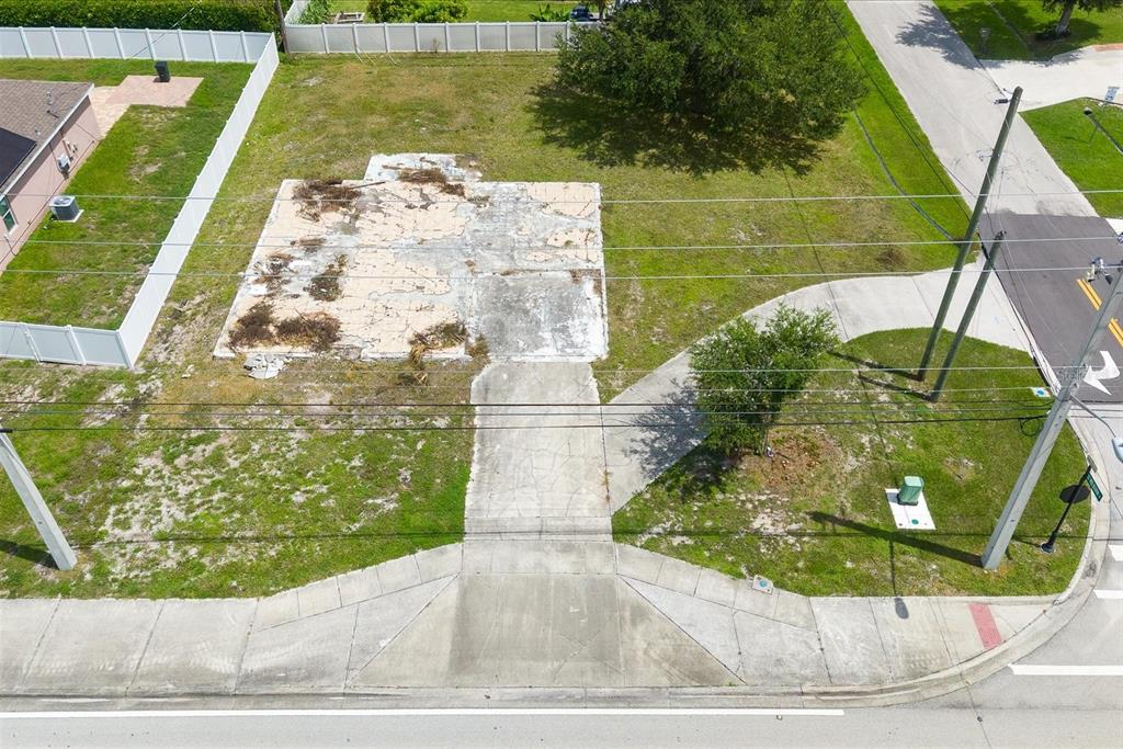 An aerial view shows a vacant residential lot with a concrete slab foundation and driveway — 221 SW BECKER ROAD, PORT ST LUCIE, FL