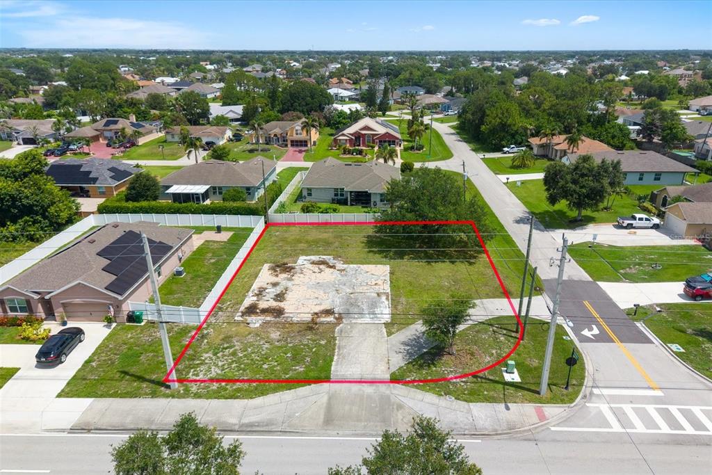 An aerial view shows a vacant residential lot outlined in red with a concrete foundation — 221 SW BECKER ROAD, PORT ST LUCIE, FL