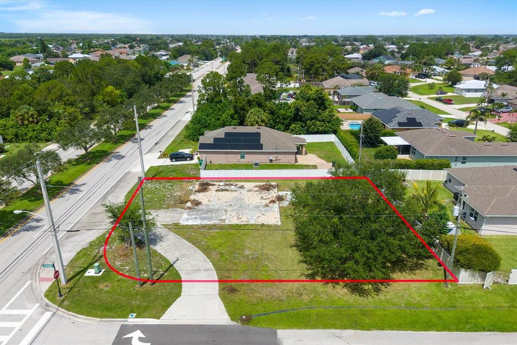 An aerial view shows a vacant residential lot with a concrete slab foundation and trees — 221 SW BECKER ROAD, PORT ST LUCIE, FL