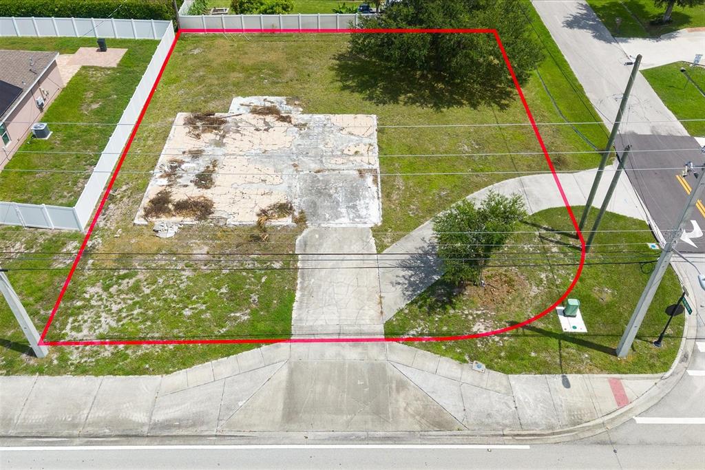 An aerial view shows a vacant residential lot with a concrete foundation and a driveway — 221 SW BECKER ROAD, PORT ST LUCIE, FL