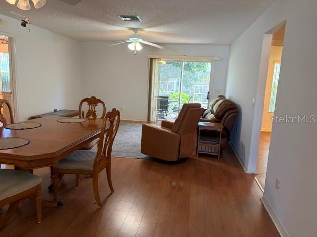 A dining area with a wooden table leads into a living room with a recliner — 17663 SE 92ND GRANTHAM TERRACE, THE VILLAGES, FL
