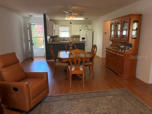 A dining area with a wooden table and chairs sits between a living room and kitchen — 17663 SE 92ND GRANTHAM TERRACE, THE VILLAGES, FL