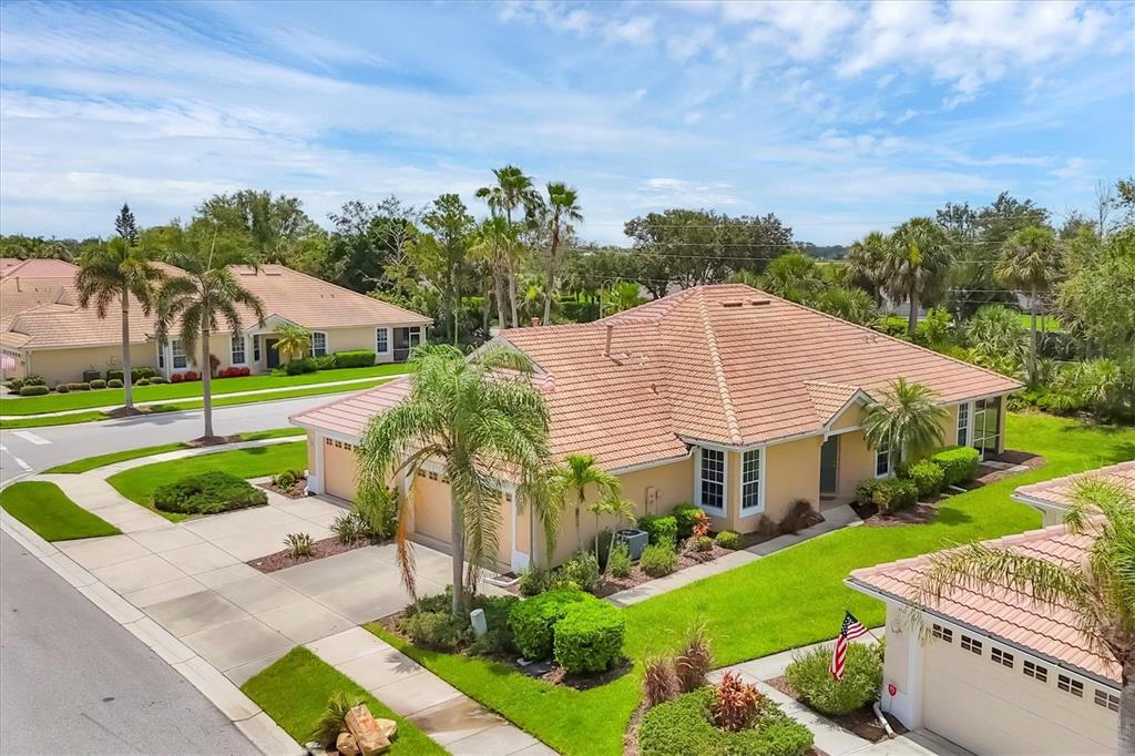 An aerial view of a tan house with a tiled roof and a palm tree — 4841 WHISPERING OAKS DRIVE, NORTH PORT, FL