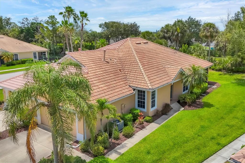 An aerial view of a tan house with a tiled roof and surrounding landscaping — 4841 WHISPERING OAKS DRIVE, NORTH PORT, FL