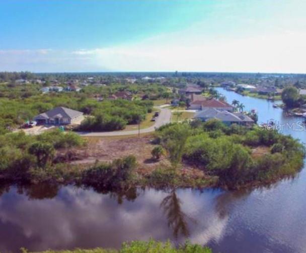 An aerial view of a residential neighborhood with houses, a canal, and surrounding vegetation — 15642 APPLEWHITE CIRCLE, PORT CHARLOTTE, FL