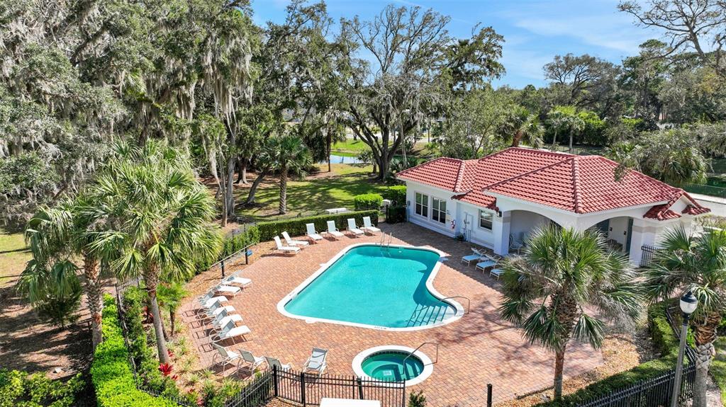 An aerial view of a swimming pool and hot tub with a clubhouse nearby — 227 MISTY HARBOR TRACE, PALM COAST, FL