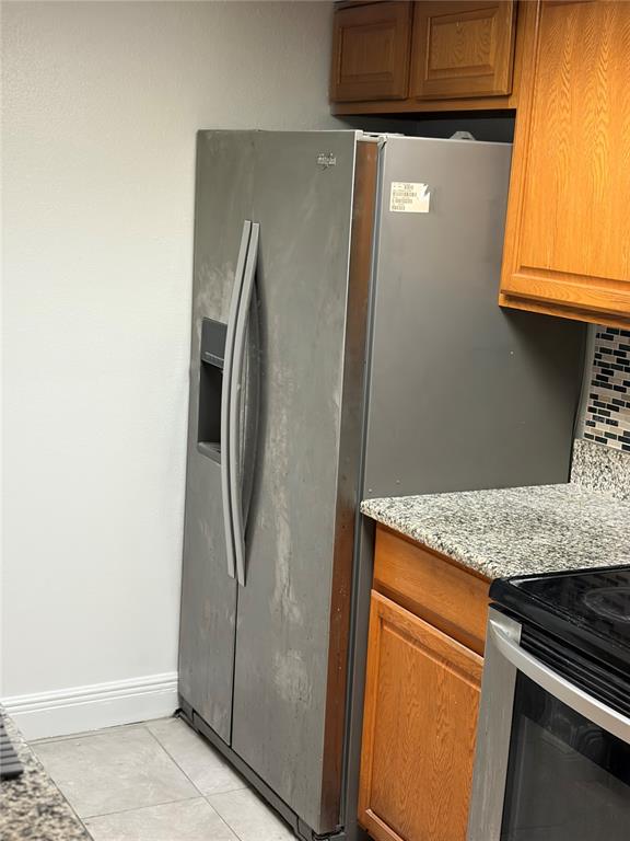 A stainless steel side-by-side refrigerator stands next to wooden cabinets and a granite countertop — 2717 N POINCIANA BOULEVARD UNIT 169, KISSIMMEE, FL