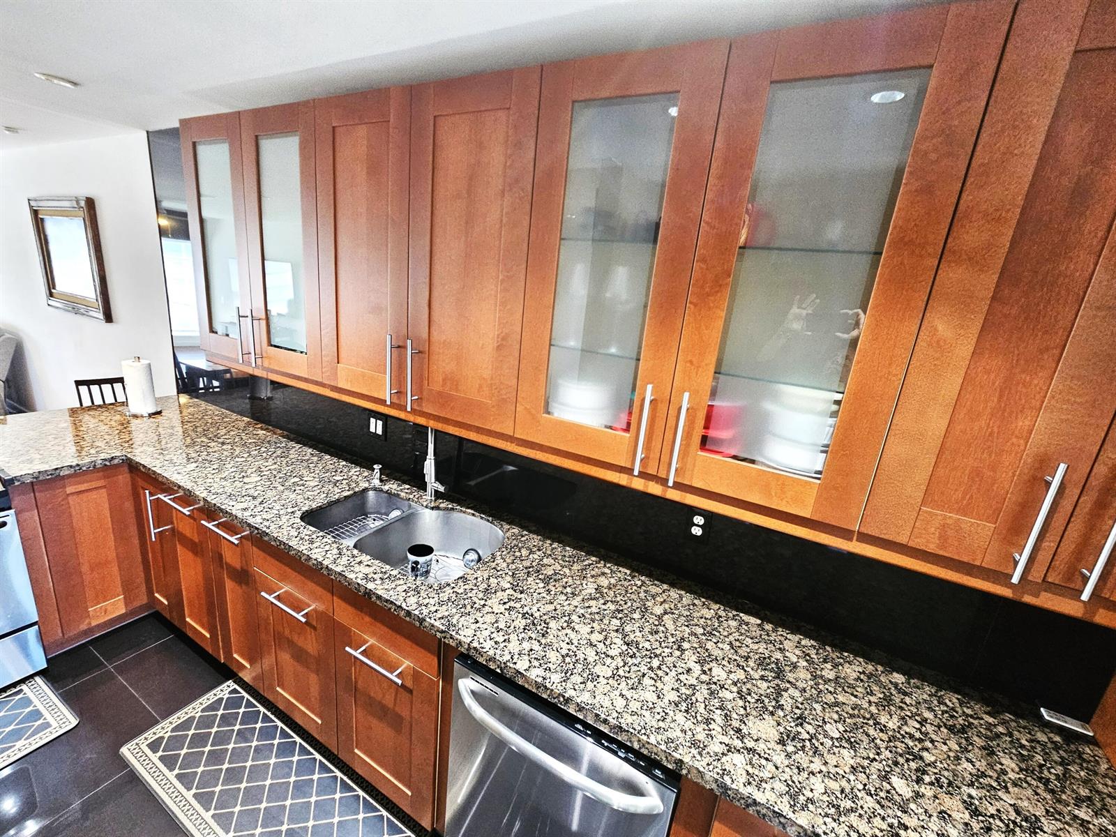 A kitchen features wood cabinets, granite countertops, a stainless steel sink, and a dishwasher — 1141 Violet Terrace # 201, Delray Beach FL 33445, DELRAY BEACH, FL