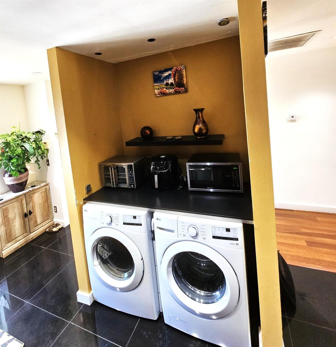 A laundry area features two white front-load washers beneath a black counter with small appliances — 1141 Violet Terrace # 201, Delray Beach FL 33445, DELRAY BEACH, FL